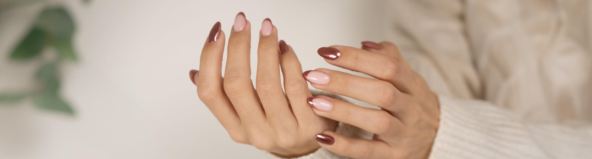 Manos con uñas largas esmaltadas en tonos nude y metálico, manicura elegante en casa