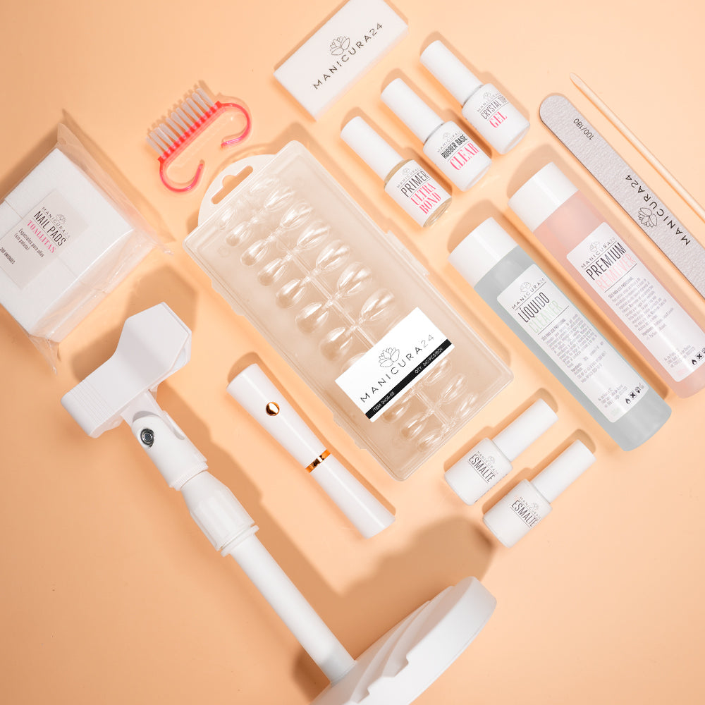 Kit de manicura profesional con uñas postizas, esmaltes, limas y accesorios sobre fondo beige