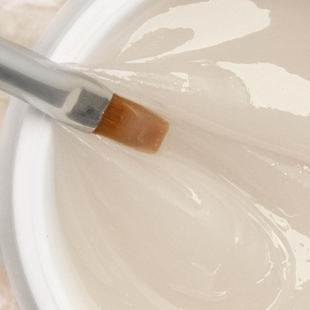 Gel constructor transparente para uñas siendo aplicado con pincel, ideal para manicura profesional.