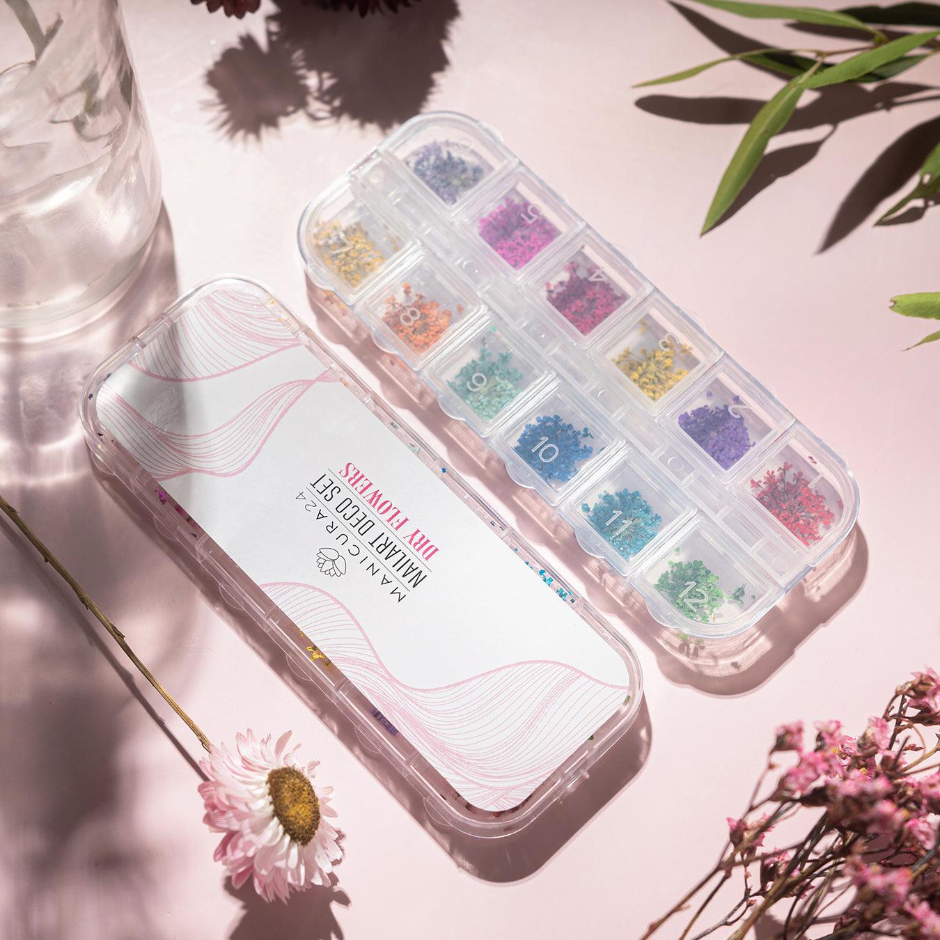 Set de decoración para uñas con flores secas de colores en organizador de plástico, ideal para nail art.