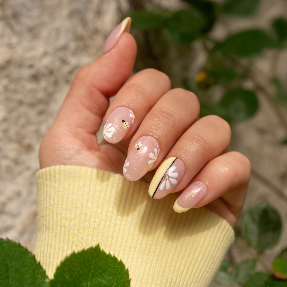 Uñas decoradas con diseño floral de margaritas y abejas en tonos pastel, manicura primavera.