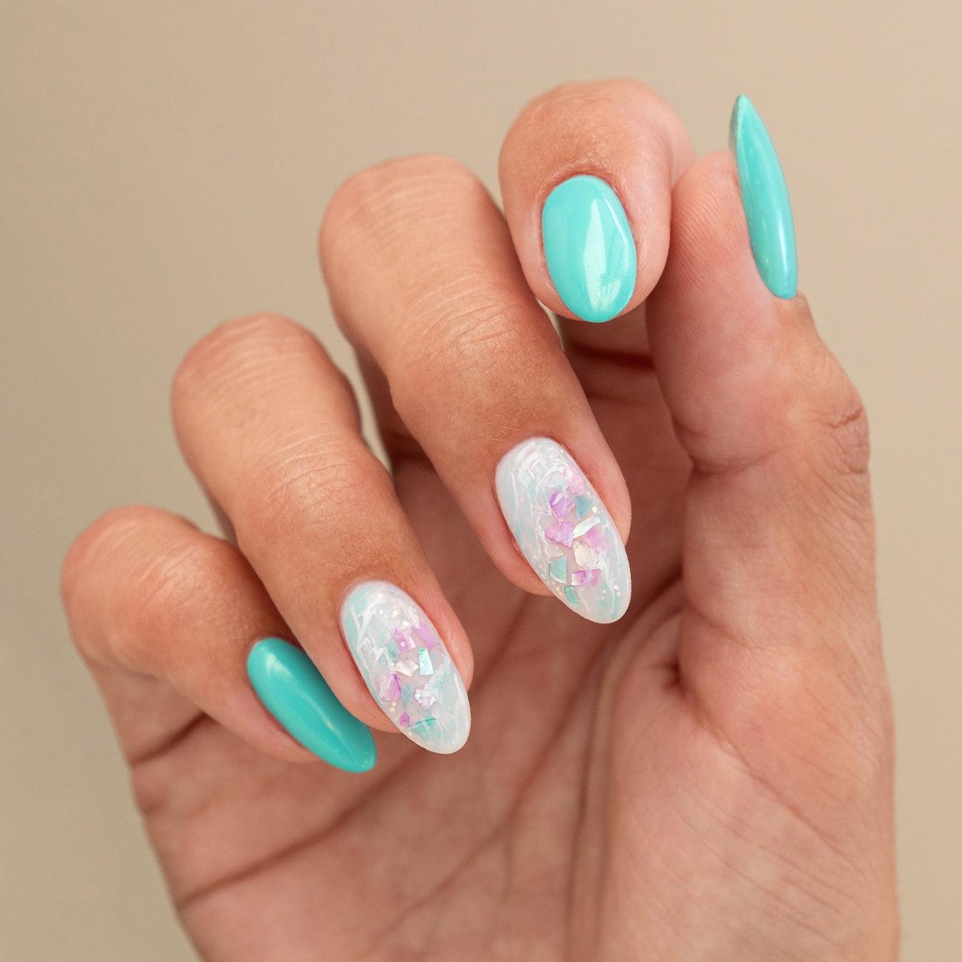 Uñas decoradas con esmalte turquesa y diseño de perlas iridiscentes para nail art