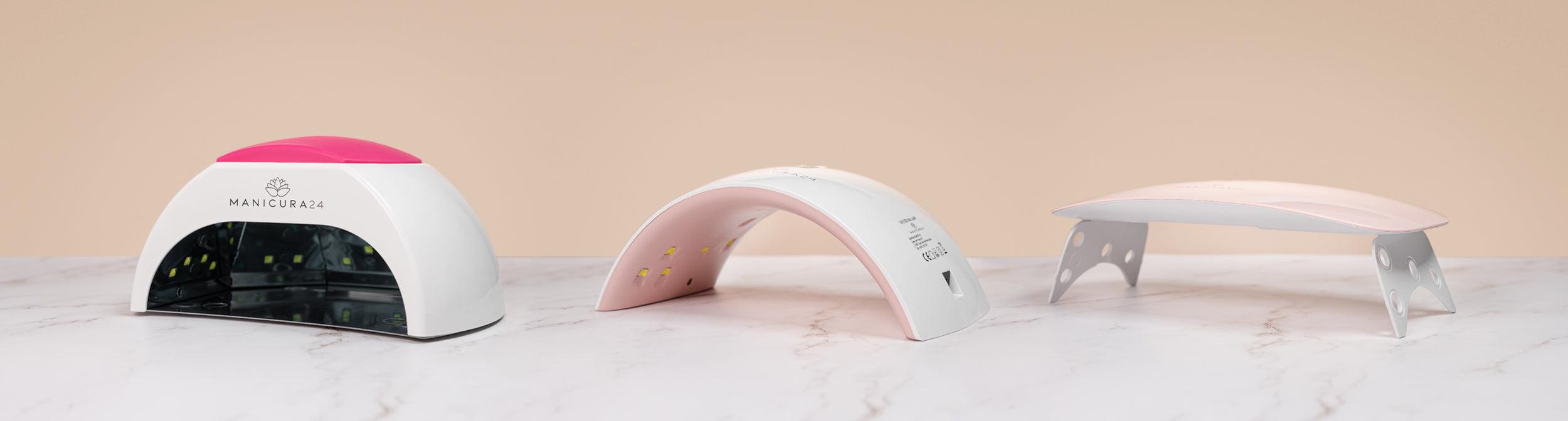 Tres lámparas LED UV para uñas sobre fondo beige y superficie de mármol