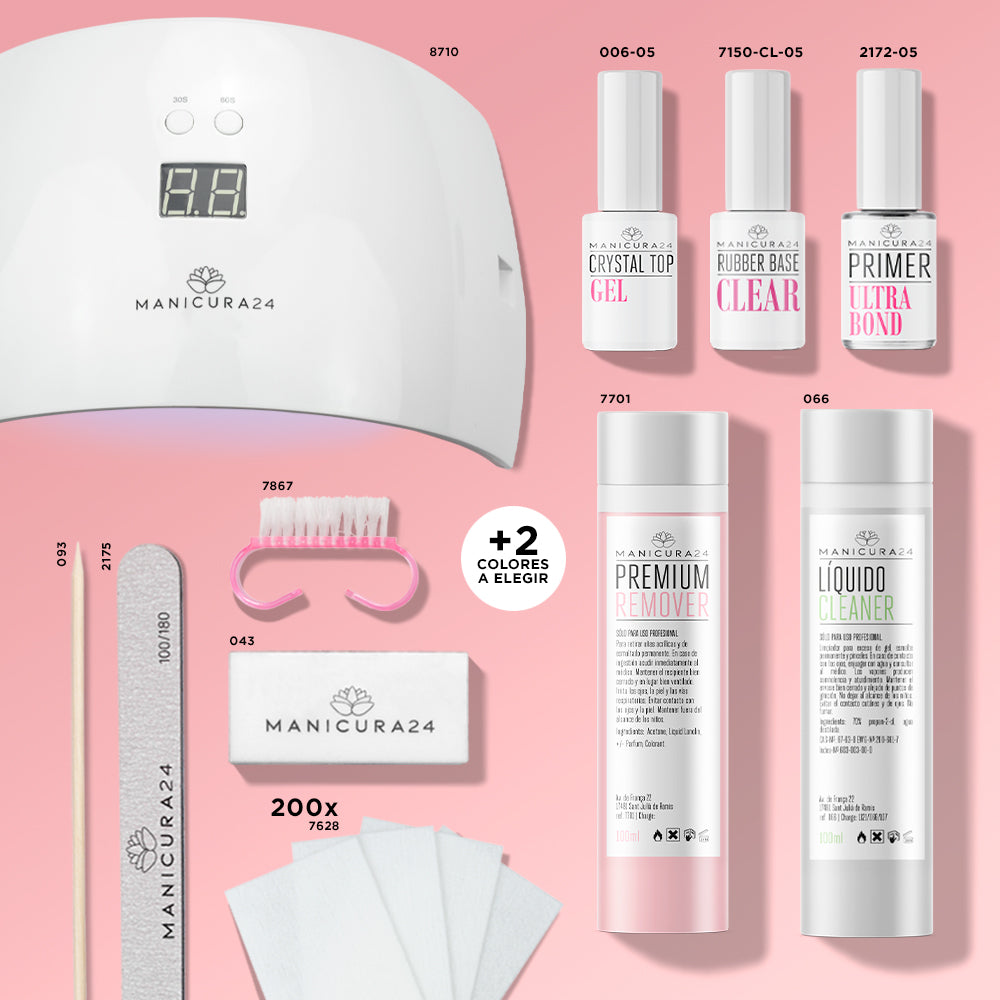 Kit de manicura con lámpara LED, esmaltes, limas, líquidos limpiadores y accesorios sobre fondo rosa.